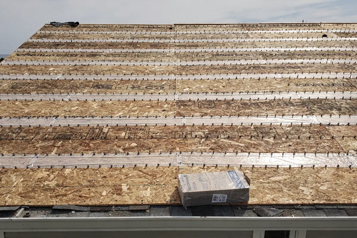 A bare roof deck with every panel seam covered by sealed tape and fasteners set close along the joints.